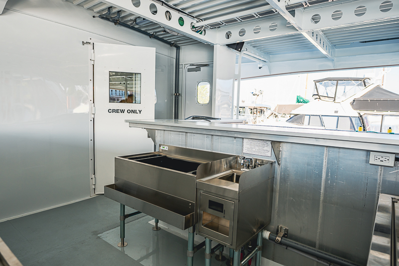 HBC_El Escudo_Marketing_Onboard_Web-5 Industrial boat galley with stainless steel appliances and a 'Crew Only' door
