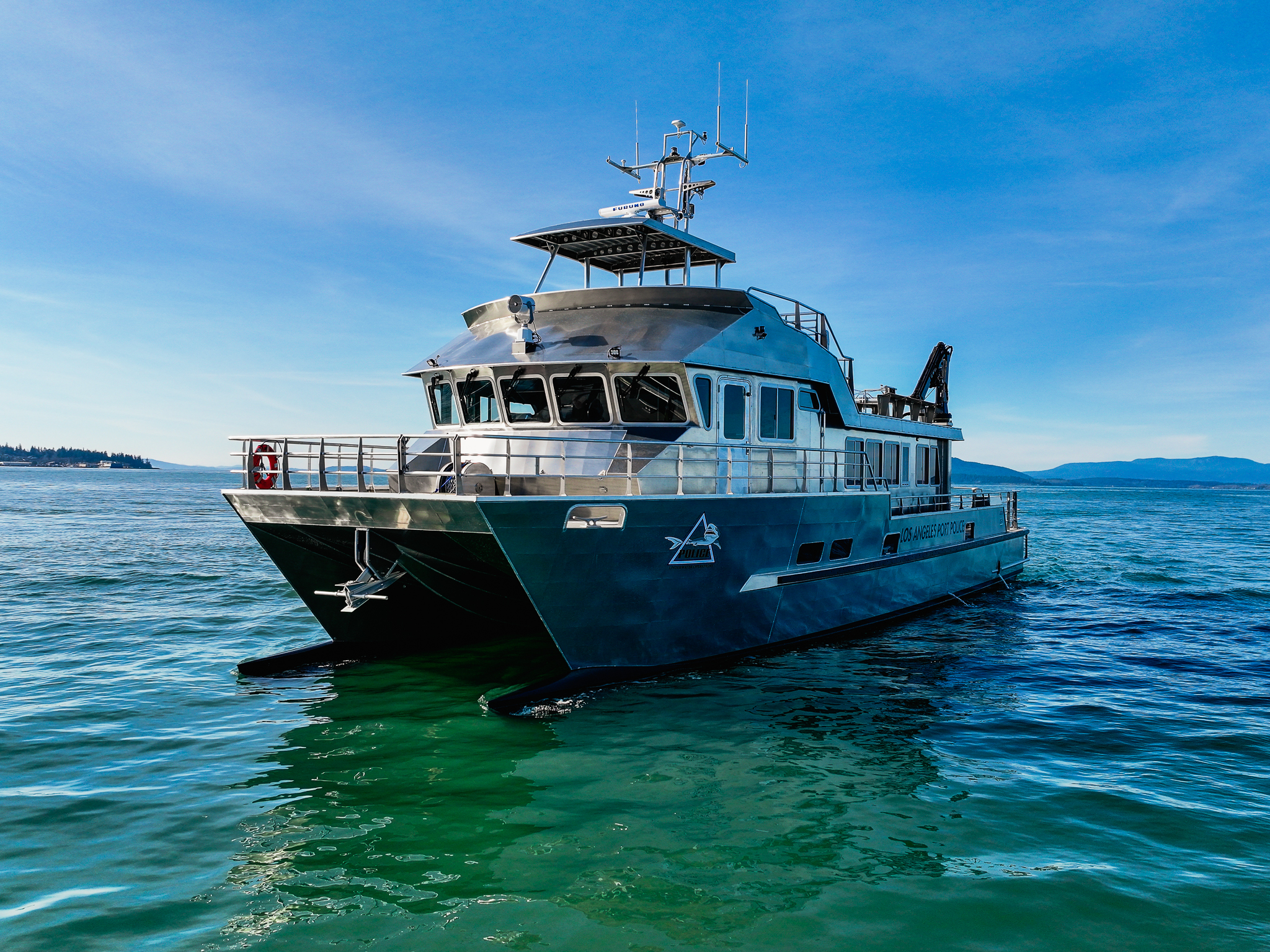 Los Angeles Port Police patrol vessel on calm blue water with a clear sky above.